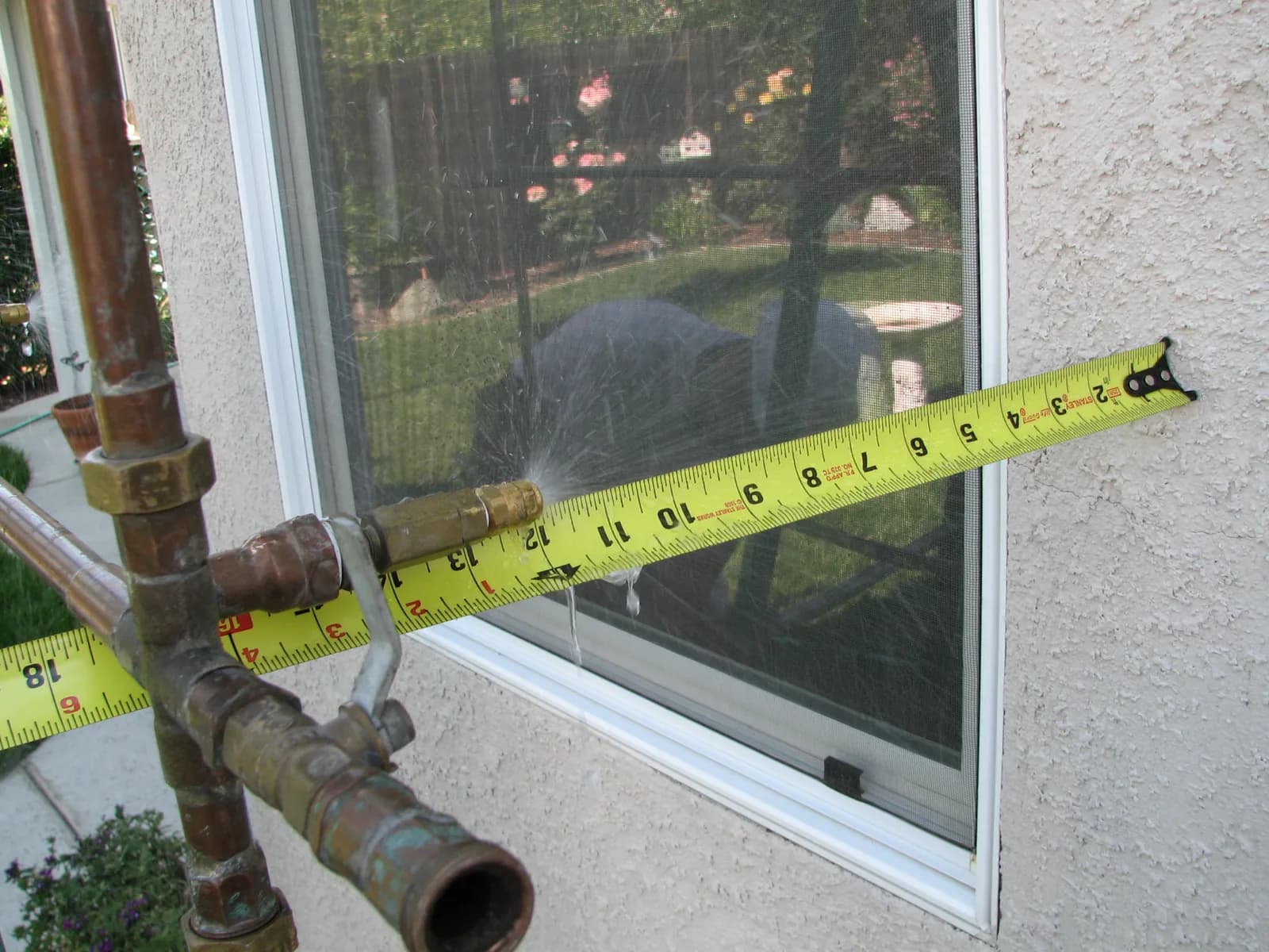 Documentation of a window water test showing test equipment against the building