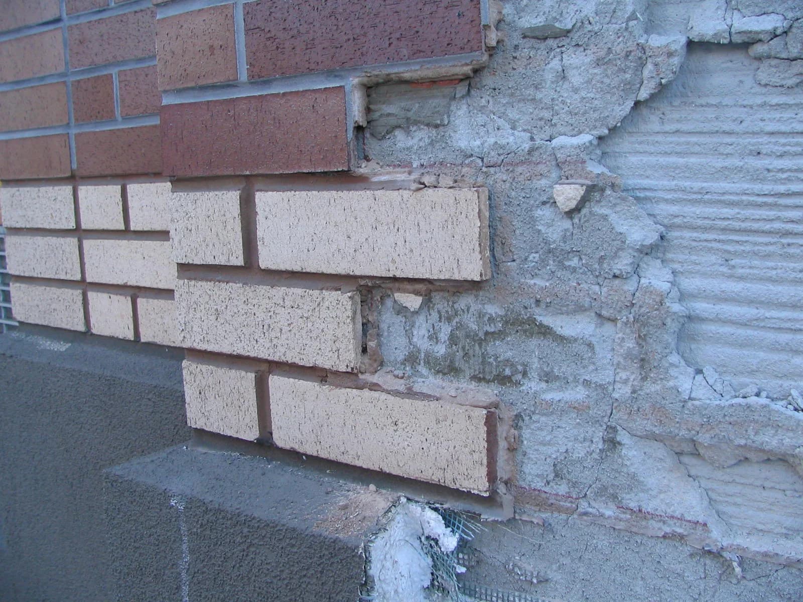 Opened stucco wall assembly revealing conditions that inform repair cost estimates